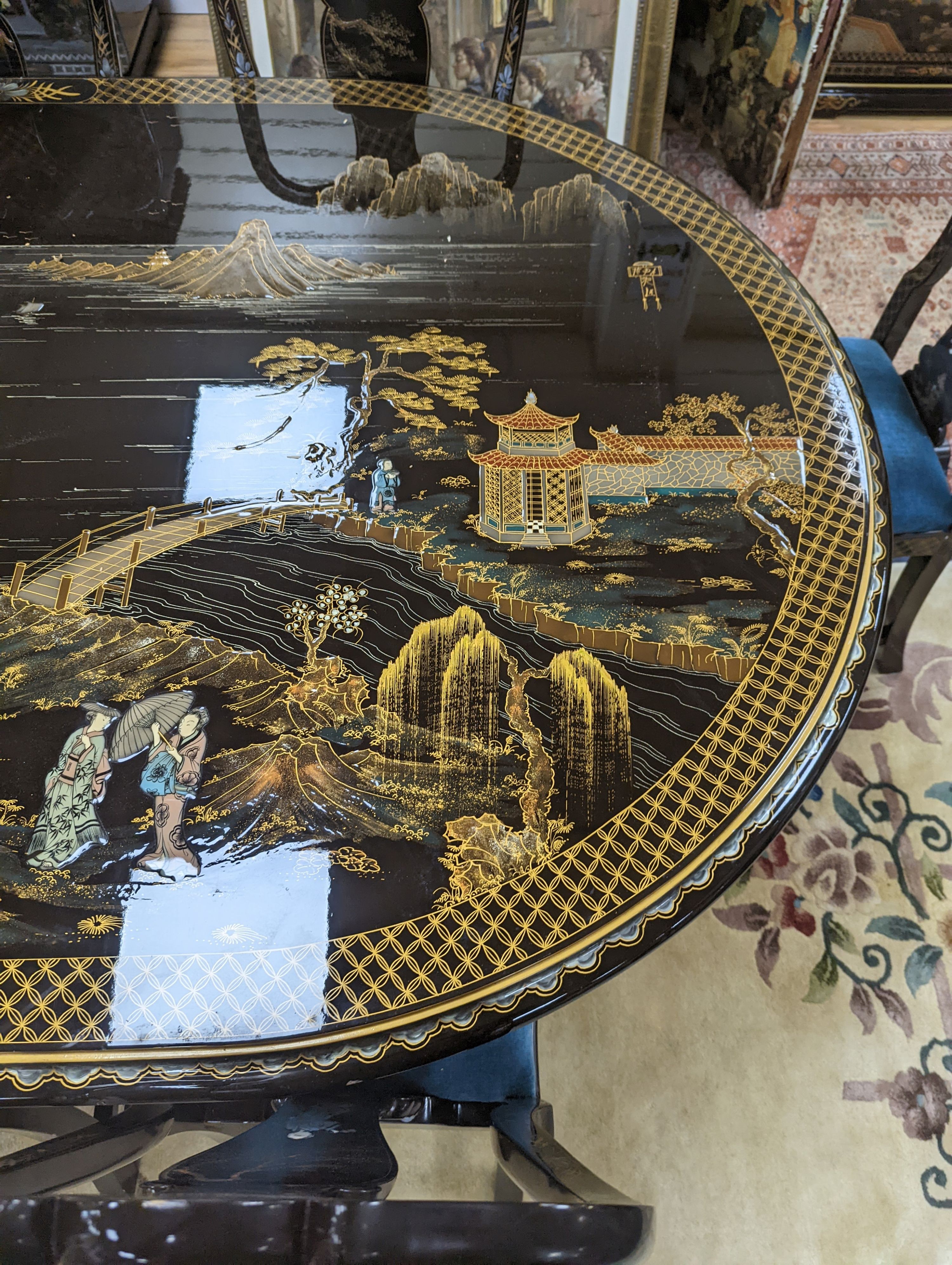 A Chinese lacquer decorated dining table and 12 chairs. Length -277cm, Depth- 120cm, Height - 74cm.